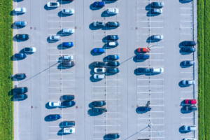 Parking lot with numerous empty spaces and green grass border